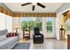 This sunroom has a ceiling fan, a couch, a chair, and windows looking out to the yard at 4721 Tara View Road, Leesburg, FL 34748