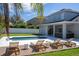 Backyard with a swimming pool, lounge chairs, and an outdoor kitchen at 5006 Legacy Oaks Dr, Orlando, FL 32839