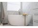 Modern bathroom with freestanding tub, marble tile, and natural light at 5006 Legacy Oaks Dr, Orlando, FL 32839