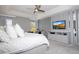 Relaxing primary bedroom features a gray wall, large bed, television, and an ensuite bathroom entrance at 5006 Legacy Oaks Dr, Orlando, FL 32839