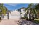 Charming two-story home with manicured landscaping, paver driveway, and attached two car garage at 5006 Legacy Oaks Dr, Orlando, FL 32839