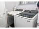 Modern laundry room with front loading Samsung washer and dryer and white cabinets at 5006 Legacy Oaks Dr, Orlando, FL 32839