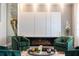 Comfortable living area featuring a modern fireplace, green armchairs, and stylish accents at 5006 Legacy Oaks Dr, Orlando, FL 32839