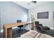 A cozy office space with a large wooden desk, comfortable chair, and natural light from the window at 5006 Legacy Oaks Dr, Orlando, FL 32839