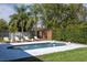 Backyard pool with white tiled deck surrounded by lush landscaping and lounge chairs at 5006 Legacy Oaks Dr, Orlando, FL 32839