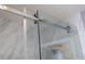 Detail of the modern glass shower door with polished silver hardware at 5006 Legacy Oaks Dr, Orlando, FL 32839