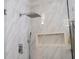 Bright shower with a marble-like tile, a rainfall showerhead, handheld sprayer, and built-in niche at 5006 Legacy Oaks Dr, Orlando, FL 32839