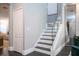 Staircase with white banister and wooden stairs, featuring dark laminate flooring and a nearby closet at 5006 Legacy Oaks Dr, Orlando, FL 32839