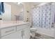 Well-lit bathroom featuring a modern vanity with white cabinets and a shower-tub combo with patterned curtain at 5058 Sparkling Water Way, Kissimmee, FL 34746
