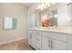 Bathroom featuring double sinks, white cabinetry, and a tile shower at 5058 Sparkling Water Way, Kissimmee, FL 34746
