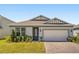Charming home with a gray exterior, brick driveway, well-manicured lawn and beautiful decorative plants at 5058 Sparkling Water Way, Kissimmee, FL 34746