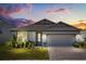 Charming home with a gray exterior, brick driveway, well-manicured lawn and beautiful decorative plants at 5058 Sparkling Water Way, Kissimmee, FL 34746