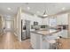 Modern kitchen with stainless steel appliances, white cabinetry, island with bar seating and tile flooring at 5058 Sparkling Water Way, Kissimmee, FL 34746
