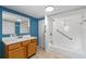 Bathroom featuring a tub/shower combo with safety bars and a wood vanity at 519 Pearl St, Mascotte, FL 34753