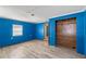 Bedroom with new flooring, blue accent wall and a closet at 519 Pearl St, Mascotte, FL 34753