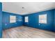 Bedroom with new flooring, blue accent wall and three windows letting in plenty of light at 519 Pearl St, Mascotte, FL 34753