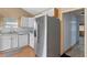 Kitchen featuring stainless steel fridge, white cabinets, and tiled backsplash at 519 Pearl St, Mascotte, FL 34753