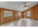 Spacious living room with wood paneling, ample natural light, and vinyl flooring at 519 Pearl St, Mascotte, FL 34753