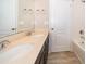 Bathroom featuring double sinks, dark cabinets, neutral countertops, and wood-look flooring at 6097 Monterey Cypress Trl, Sanford, FL 32773
