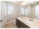 Bathroom featuring double sinks, dark cabinets, neutral countertops, and wood-look flooring at 6097 Monterey Cypress Trl, Sanford, FL 32773