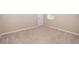 A carpeted bedroom showcases a neutral color scheme, complemented by white baseboards, door, and trim for a clean and modern look at 6097 Monterey Cypress Trl, Sanford, FL 32773