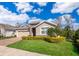 Charming single-story home boasts a well-manicured lawn, brick driveway and stone accents at 6097 Monterey Cypress Trl, Sanford, FL 32773