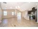 Open-concept living room and kitchen featuring wood-look floors and ample natural light at 6097 Monterey Cypress Trl, Sanford, FL 32773
