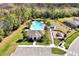 Aerial view of community pool, playground, parking, and amenity center surrounded by mature trees at 869 Rivers Crossing St, Clermont, FL 34714