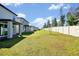 Expansive backyard featuring lush green grass, a tall privacy fence, and mature trees at 869 Rivers Crossing St, Clermont, FL 34714