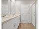 Bathroom with dual sinks, white cabinetry, and a glass-enclosed shower, offering a spa-like experience at 869 Rivers Crossing St, Clermont, FL 34714