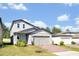 Charming two-story home featuring gray siding, a brick driveway, and a light blue front door at 869 Rivers Crossing St, Clermont, FL 34714