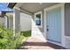 Close-up of a light blue front door with brick walkway and gray trim at 869 Rivers Crossing St, Clermont, FL 34714
