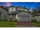 Charming two-story home with brick driveway, a two-car garage, and well-maintained landscaping at 869 Rivers Crossing St, Clermont, FL 34714