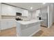 Modern kitchen featuring white cabinets, stainless steel appliances, and an island with a sink at 869 Rivers Crossing St, Clermont, FL 34714