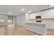 Open kitchen with white cabinets, quartz countertops, and stainless steel appliances at 869 Rivers Crossing St, Clermont, FL 34714