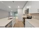 Open-concept kitchen with stainless steel appliances, white cabinetry, and a view of the dining area at 869 Rivers Crossing St, Clermont, FL 34714