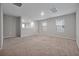 Spacious loft with plush carpeting, neutral walls, and ample natural light from the large windows at 869 Rivers Crossing St, Clermont, FL 34714