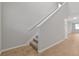 A staircase with carpeted steps, white handrail, and tiled floors at 869 Rivers Crossing St, Clermont, FL 34714