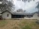 Rear view of the home featuring a porch, solar panels, and a spacious backyard at 1102 Hamlin Ave, Howey In The Hills, FL 34737