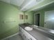 This bathroom has a sink with a large mirror and white cabinets at 1102 Hamlin Ave, Howey In The Hills, FL 34737