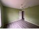 This bedroom features light green walls, wood-look floors, and a ceiling fan at 1102 Hamlin Ave, Howey In The Hills, FL 34737