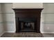 Close-up of a dark wood fireplace with floating shelves and brick hearth at 1102 Hamlin Ave, Howey In The Hills, FL 34737