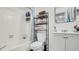 Bathroom with a tub shower, vanity with a mirror, and storage shelves above the toilet at 11336 Bingham Ct, Orlando, FL 32837