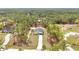 Aerial view of a home with an extended driveway, surrounded by lush trees in a serene setting at 12380 Sw 71St Lane Rd, Ocala, FL 34481