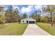 Beautiful single-story home with a large lawn and a long driveway leading up to the garage at 12380 Sw 71St Lane Rd, Ocala, FL 34481