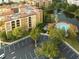 Aerial view of a resort complex with a pool, parking, and access to a scenic lake at 12527 Floridays Resort Dr # 401E, Orlando, FL 32821