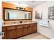 Bathroom with double sinks, granite counters, and a large mirror at 12527 Floridays Resort Dr # 401E, Orlando, FL 32821