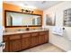Spacious bathroom featuring double sinks, granite countertop, and large mirror at 12527 Floridays Resort Dr # 401E, Orlando, FL 32821