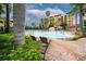Gorgeous community pool with lounge chairs and nearby lush tropical plants at 12527 Floridays Resort Dr # 401E, Orlando, FL 32821