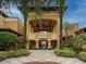 Inviting entrance to a resort-style property with meticulously landscaped grounds and covered walkway at 12527 Floridays Resort Dr # 401E, Orlando, FL 32821